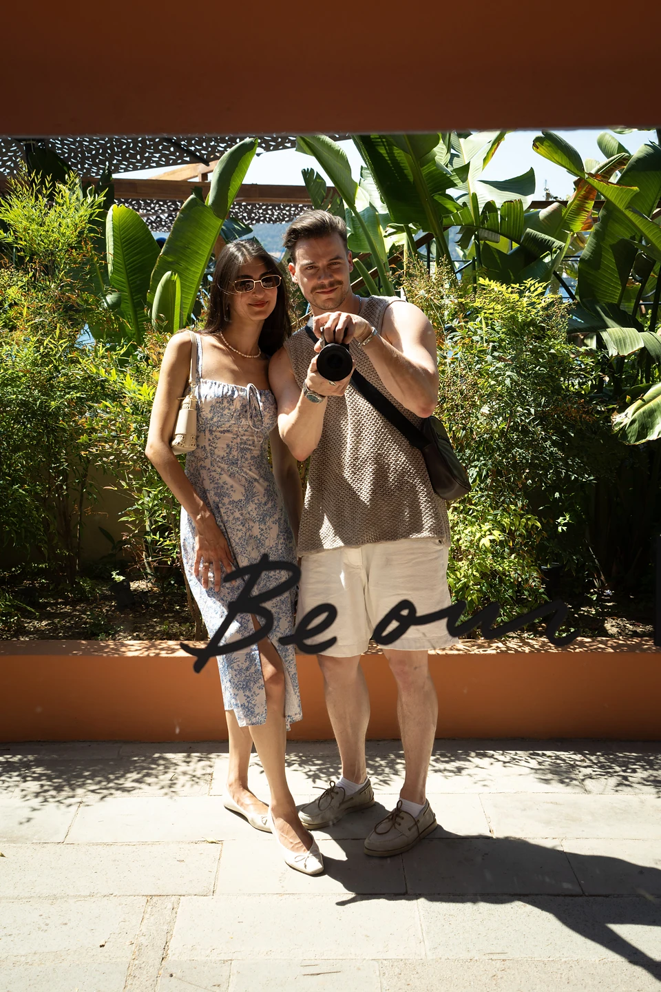 The two of us in a mirror selfie in Türkbükü, camera raised, broad leaves behind
