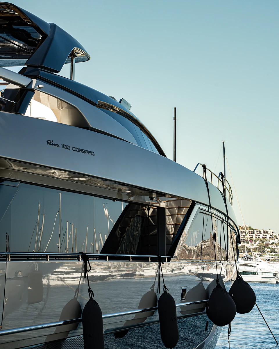 Black fenders on the mirror-polished hull of a large yacht moored in Yalıkavak