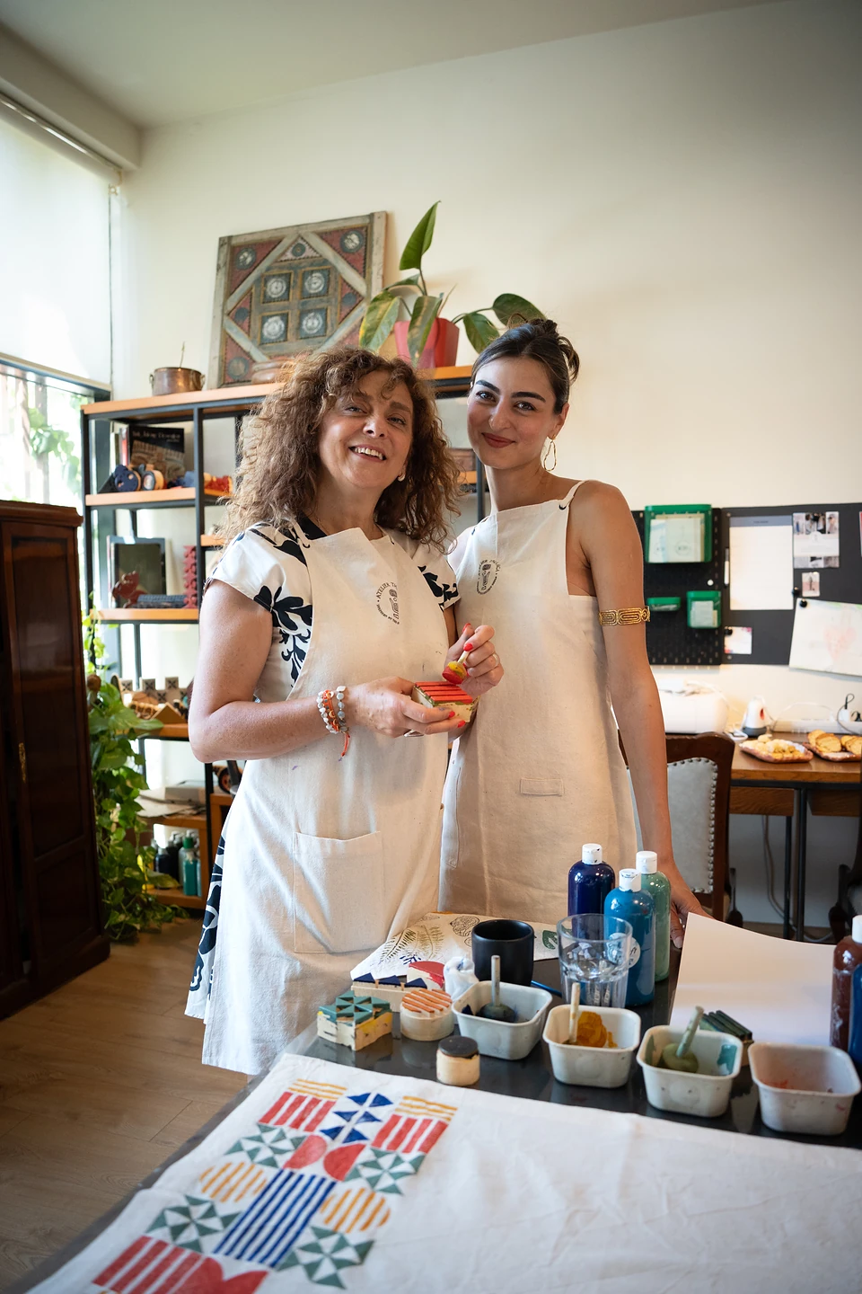 One of us and another woman smiling in aprons behind a freshly printed grid