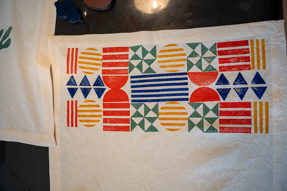 The finished grid of stamped stripes, pinwheels, triangles and circles in red, yellow, green and blue