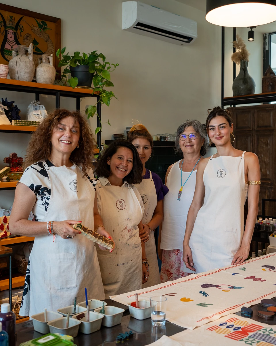 One of us and four other women smiling together behind the two finished cloths