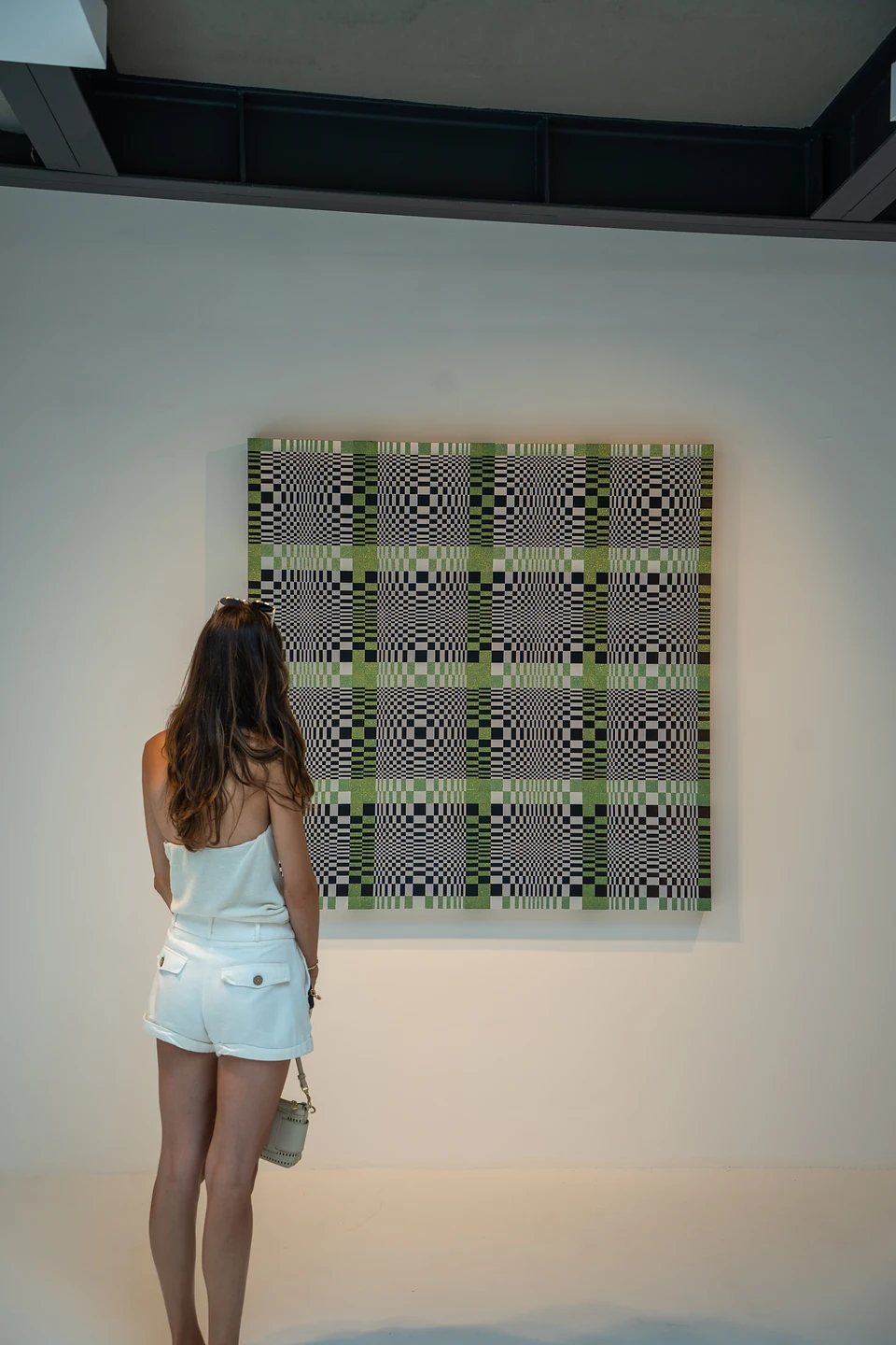 One of us looking at a large green and black chequered painting in a white gallery