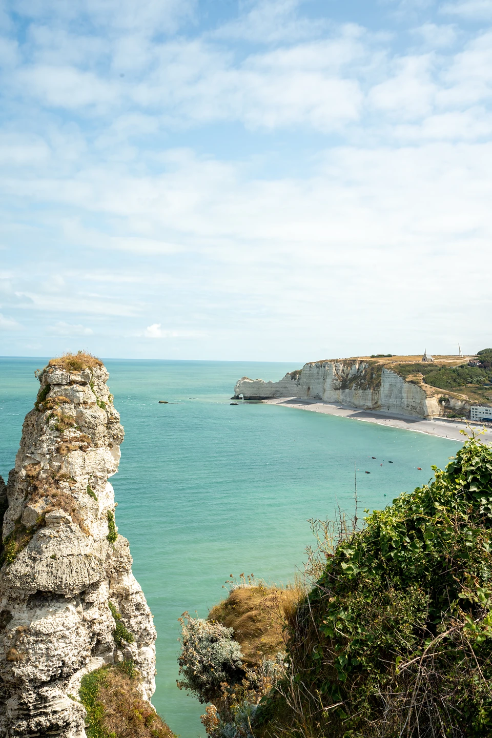 A chalk pinnacle in the foreground, across the bay the far cliffs topped by a chapel