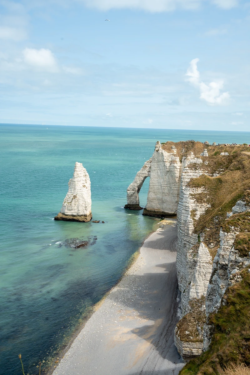 The Needle and the chalk arch over turquoise sea, a shingle beach below the cliff