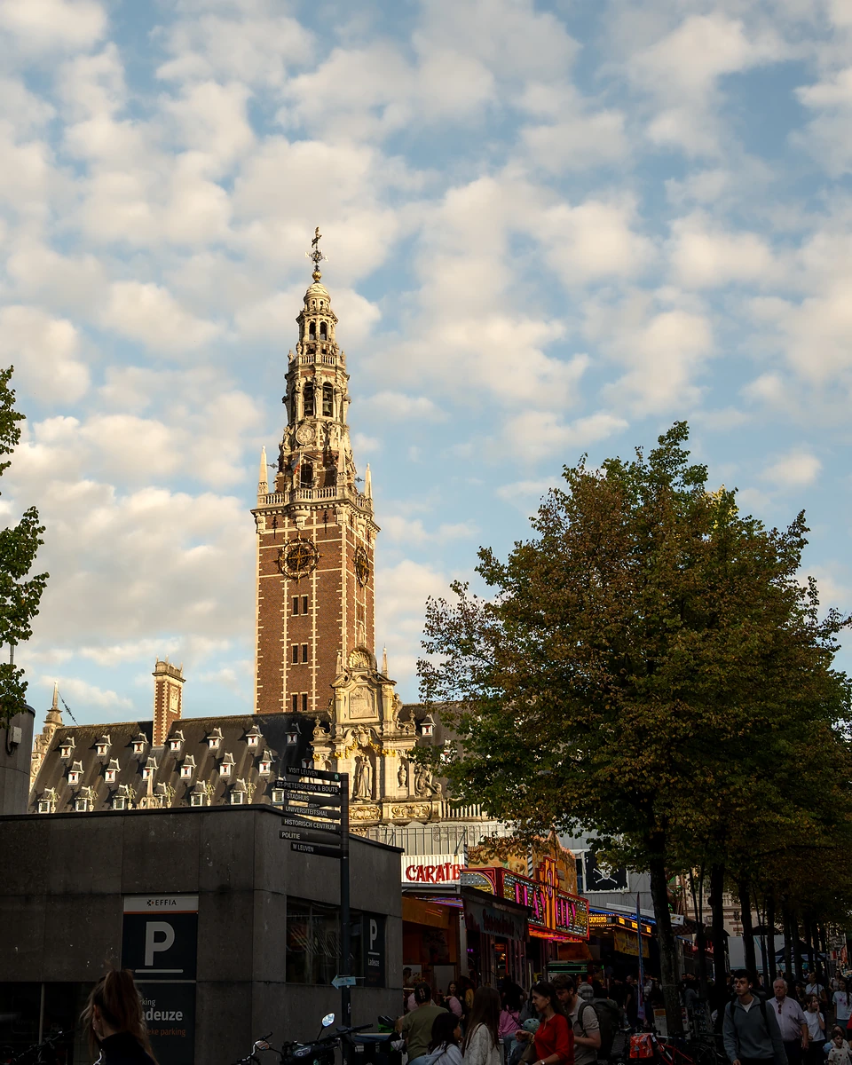 The library tower rising above the fairground crowd and trees under a sky of small clouds