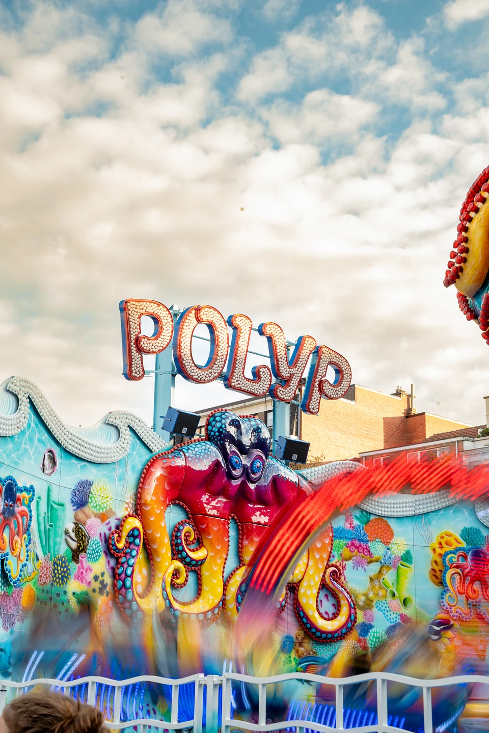 The Polyp ride spinning in a blur beneath its bulb-lit sign and a giant painted octopus
