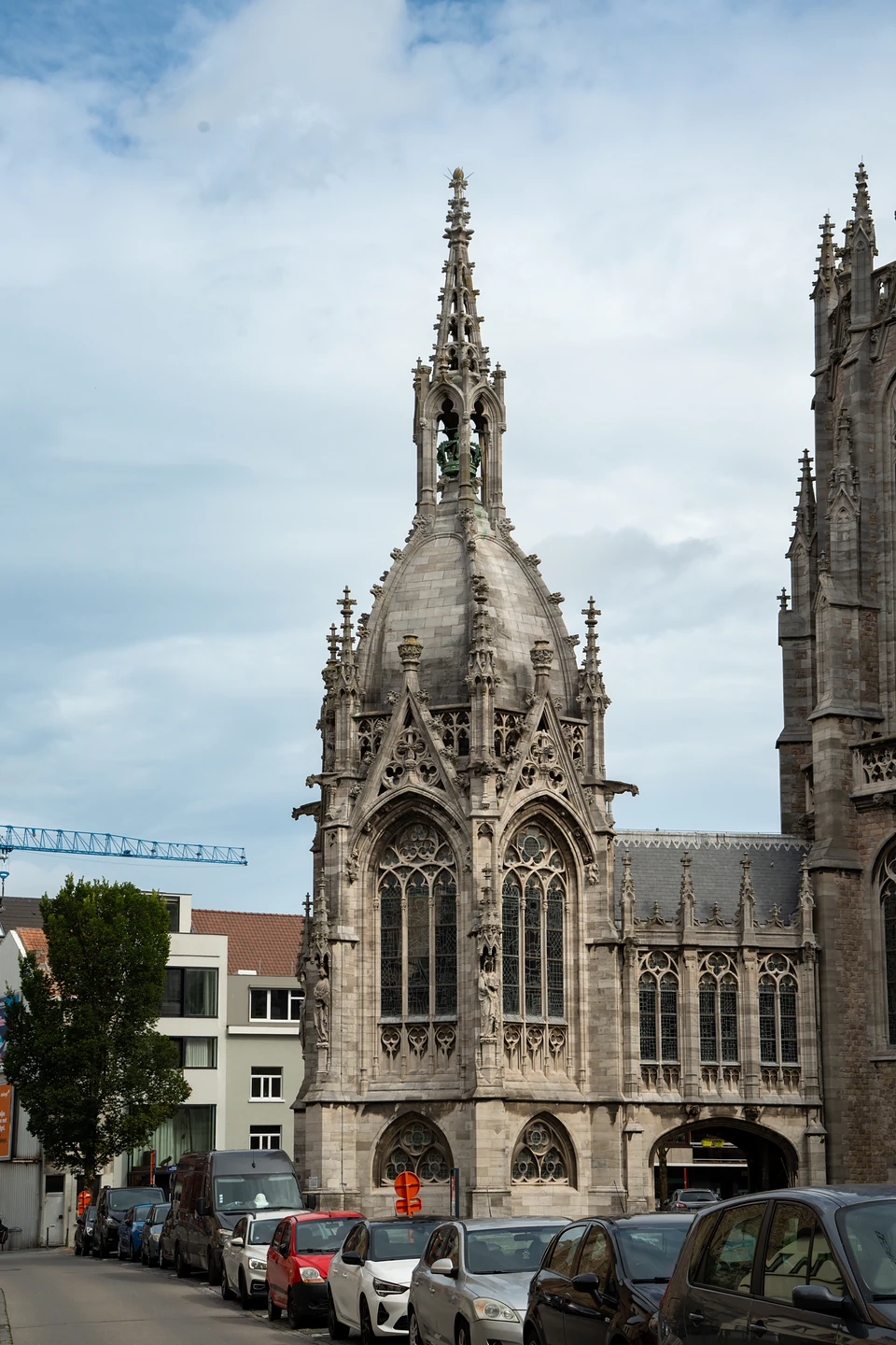 A domed Gothic-style chapel with a pinnacled bell turret, cars parked along the street below