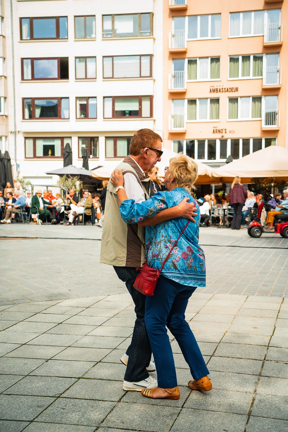 Two people dancing in each other's arms on the square to the Sunday band